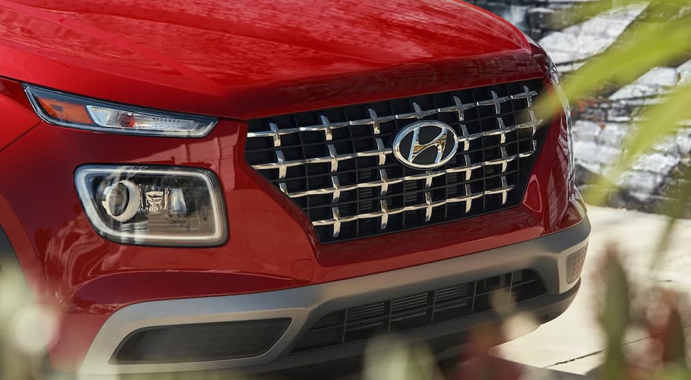 A close-up on the grille of a red 2024 Hyundai Venue.