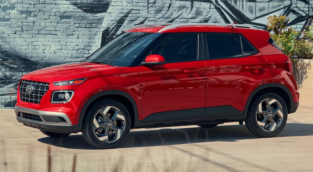 A red 2024 Hyundai Venue angled left by a Hyundai dealer near Providence.