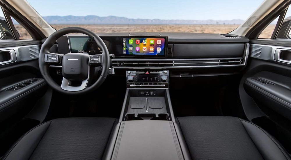 The infotainment screen and front seats in a 2024 Hyundai Santa Fe XRT at a Hyundai dealer near Fall River.