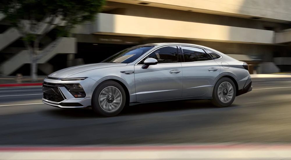 A silver 2024 Hyundai Elantra Hybrid Limited is shown driving to a Hyundai dealer near Taunton.