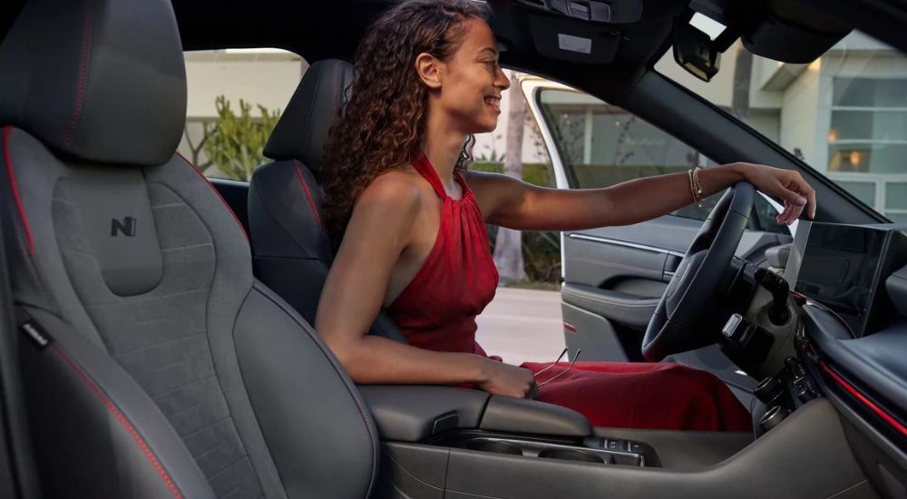 A person in a red dress is shown in a 2024 Hyundai Sonata N-Line Sport.