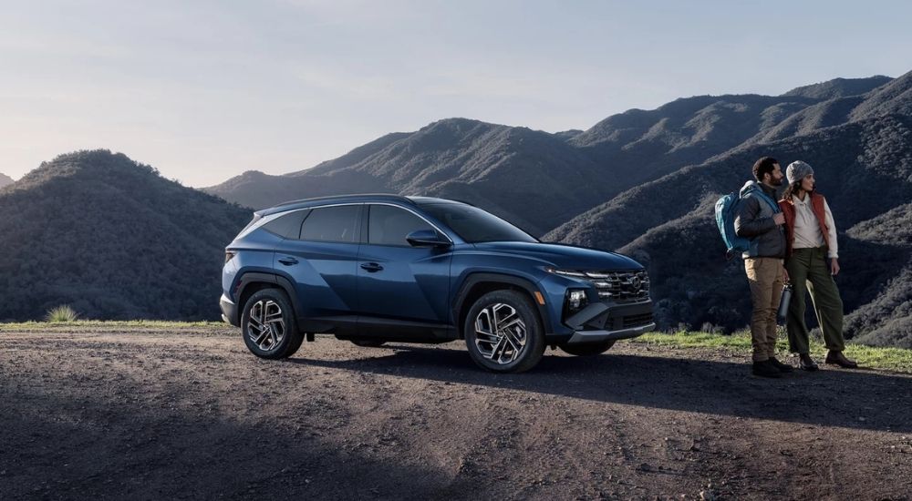 A blue 2025 Hyundai Tucson parked overlooking a mountain view.