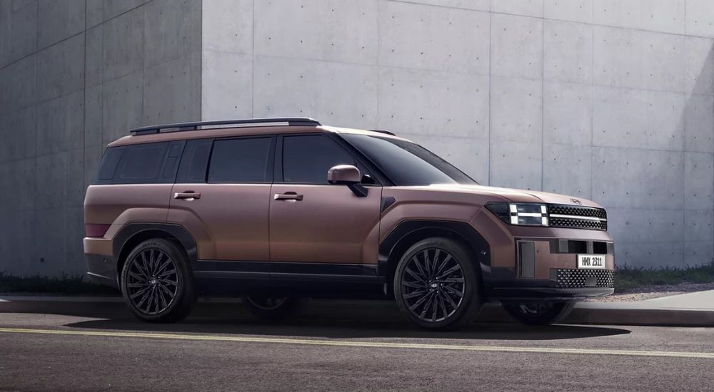 A bronze 2025 Hyundai Santa Fe is shown from the side.