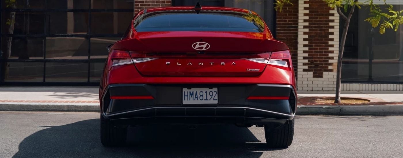 A rear view of a red 2025 Hyundai Elantra Limited in a parking spot.